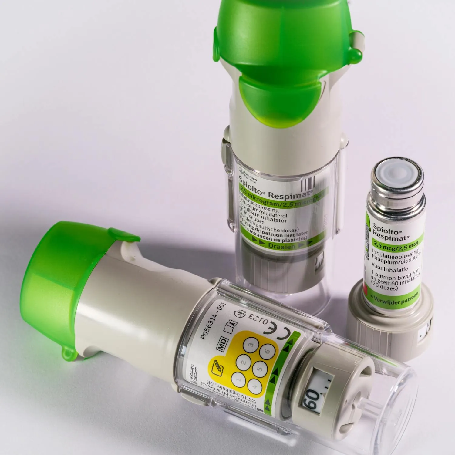 Green asthma inhalers on a clean surface, representing respiratory care